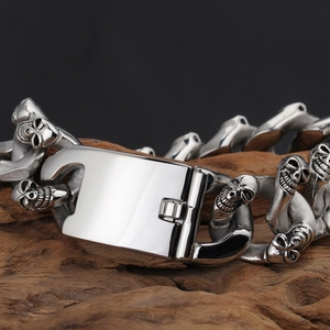 Close-up of punk double skull link bracelet with steel clasp on natural wood