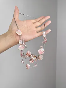 Detail of multi-layer necklace with pink irregular beads and silver metal accents