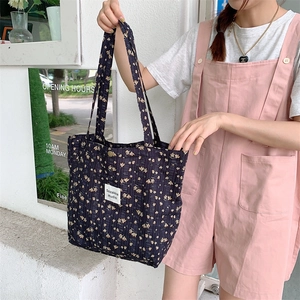 Detail of vintage floral canvas tote bag showing delicate flower patterns and brand label