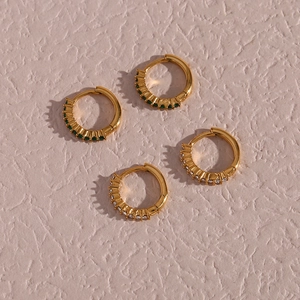 Detail of gold-plated mini hoops with green gemstones and white cubic zirconia