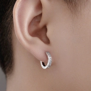 Close-up of 925 silver Roman numeral earrings with inlaid diamonds on a model's ear