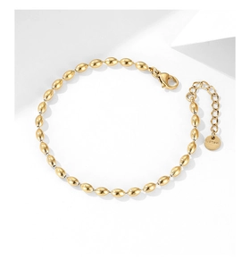 Macro shot of gold stainless steel beaded necklace with lobster clasp and tag detail