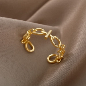 Macro detail of gold-plated chain link ring on elegant brown silk background fabric