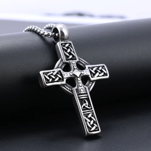 Macro shot of silver Celtic cross pendant with intricate vintage engraved patterns