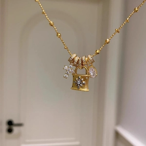 Close-up of gold-plated cross and flower bag pendants with sparkling zircon stones