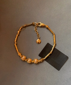 Detailed macro view of 18K gold plated bamboo link bracelet with zircon beads