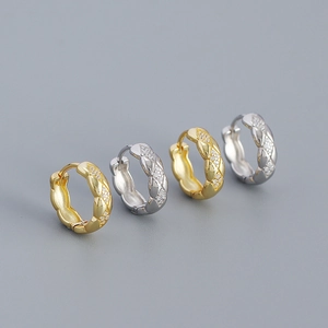 Macro detail of gold and silver quilted hoop earrings with sparkling diamond accents