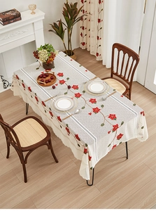 Close-up of rectangular lace tablecloth with red flower embroidery and scalloped edges