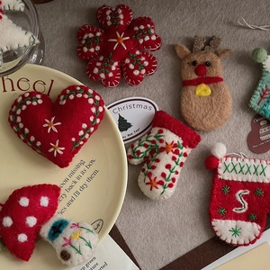 Macro shot of handmade wool felt Christmas ornaments including reindeer and festive stockings