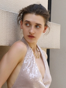 Detail of 18K gold-plated layered chain with heart and droplet charms on a female model