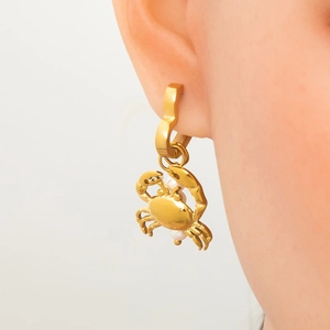 Gold stainless steel crab earrings with pearl accents shown on a female model