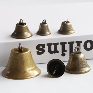 Set of vintage bronze metal cow bells in various sizes for DIY crafts and decor