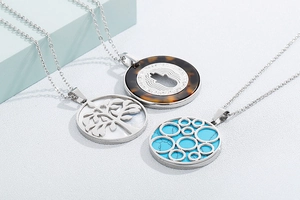 Detailed shot of three silver necklaces featuring tree of life and turquoise pendants