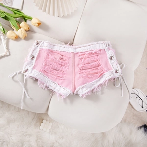 Detalle de shorts vaqueros rosas con cordones laterales, rotos y bordes deshilachados
