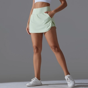 Detail view of high-waist light green tennis skirt with built-in shorts and side pocket