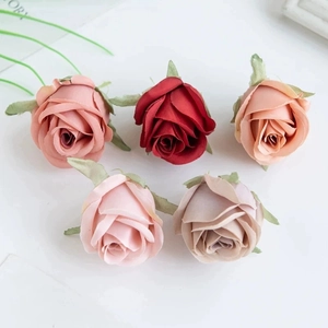 Detailed view of assorted artificial silk rose heads in red, pink, and champagne shades