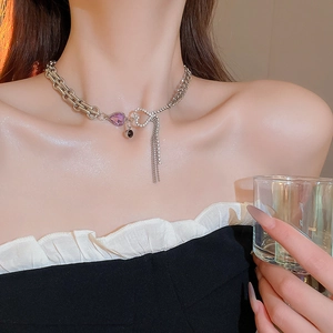 Silver chain necklace featuring a purple heart crystal and sparkling rhinestone tassels