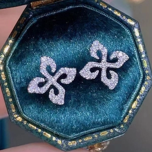 Squisiti orecchini a fiore in argento con pavé di diamanti in scatola di velluto verde