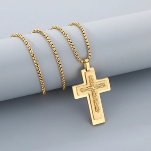 Macro detail of gold-tone stainless steel cross pendant with chain inlay and box chain