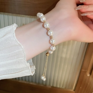 Detail of adjustable French vintage pearl bracelet with gold beads and pull-string closure