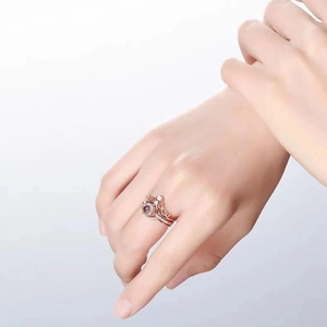 Detail of rose gold crown ring set with a projection stone shown on model's finger