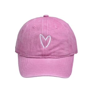 Detailansicht der rosa Baseballkappe aus gewaschener Baumwolle mit weißem Herzstickerei
