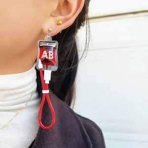Detail of creative AB blood bag earring with red liquid effect on ear for Y2K style