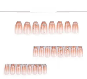 Detailansicht von rosa Ombre-Kunstnägeln mit silbernen Glitzerspitzen und Strasssteinen