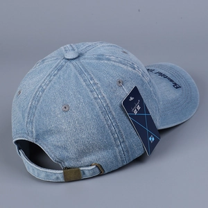 Detail view of washed denim baseball cap with side embroidery and metal adjustment buckle