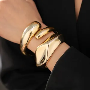 Modern polished gold irregular wavy cuff bracelet for women with minimalist fluid design