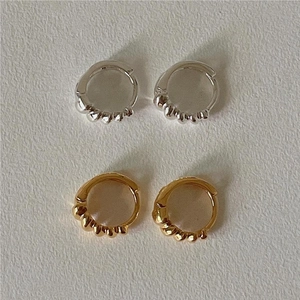Detailed view of 925 sterling silver hoop earrings with spiral texture in gold and silver