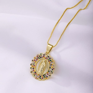 Détail du pendentif Vierge Marie en or avec zircons colorés sur fond de tissu blanc texturé