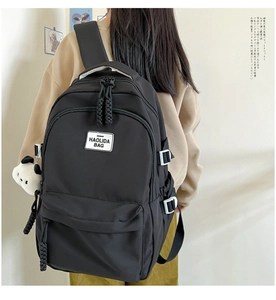 Close-up of black nylon backpack with Panda keychain and Haolida brand tag detail