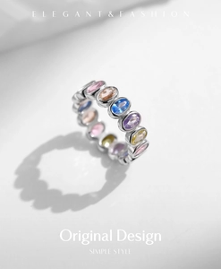 Macro shot of silver ring featuring oval colorful zircons with elegant ring shadows