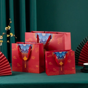 Detailed view of three red Chinese style gift bags with lanterns and cloud patterns