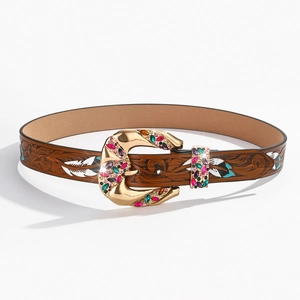 Detailed view of brown leather belt with leaf embossing and rhinestone buckle