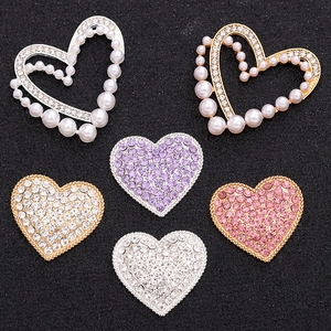 Flat lay of heart-shaped rhinestone and pearl charms for DIY shoe and phone case decor
