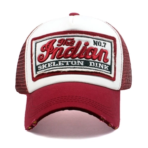 Detail of burgundy baseball cap with vintage embroidery patch and breathable mesh back