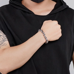 Polished silver stainless steel twisted woven bracelet for men on a male model's wrist