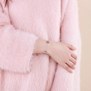 Close-up of a silver stainless steel chain bracelet with cute elephant charms on a model