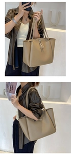Detail view of khaki leather tote bag showing smooth dual handles and zipper closure