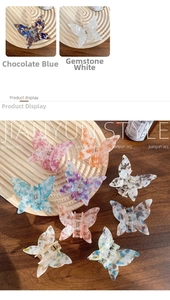 Detailed view of butterfly hair clips in Chocolate Blue and Gem White acetate