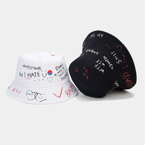 Vue détaillée des chapeaux bobs graffiti en noir et blanc avec lettrage street style