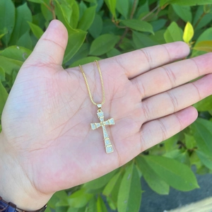 Macro detail of 18K gold plated cross pendant with micro-pave cubic zirconia stones