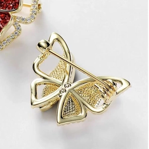 Close-up of the polished gold butterfly brooch showing the secure pin back mechanism