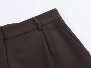 Détail de la taille du pantalon marron foncé avec passants et couture précise