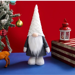 Detail of white faux fur plush gnome doll on dark blue surface with festive red background