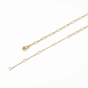 Gold 14K paperclip and flat cross necklace chains with lobster clasp on white surface