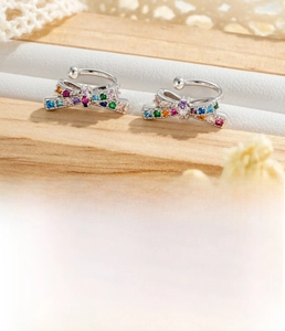 Détail du cuff d'oreille nœud argenté avec zircons colorés sur présentoir à bijoux