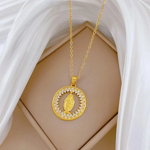Close-up of gold titanium steel pendant with religious figure and crystals